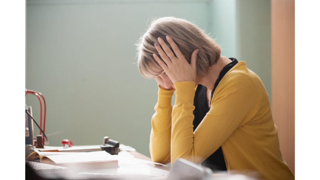 机の上で悩む女性